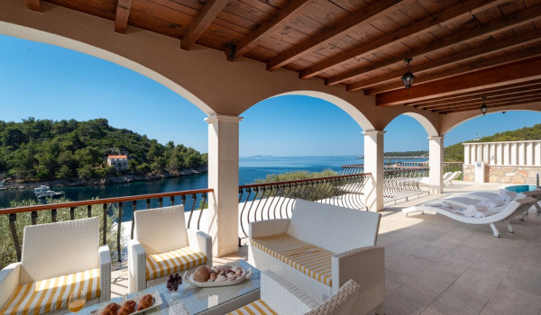 Seating area and deck chairs by the pool of the Korcula beachfront villa with sauna and jacuzzi for vacation with friends