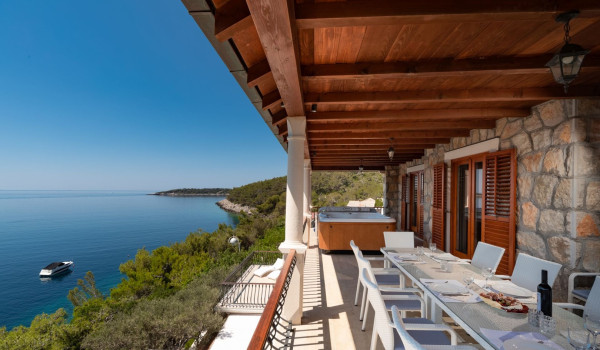 Dining table with sea view on the balcony of the luxury beachfront villa for family vacation on Korcula