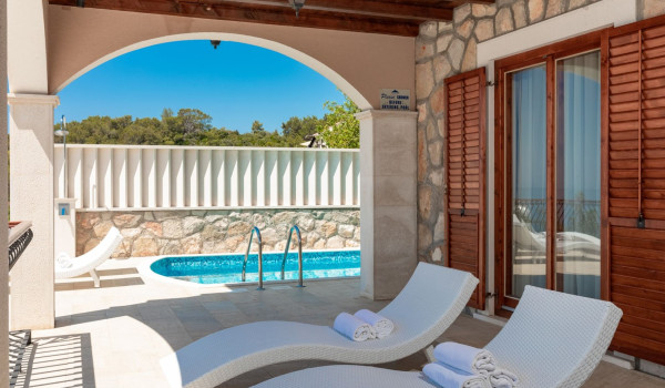 Deck chairs by the pool on the terrace of the luxury vacation villa with concierge service and private parking