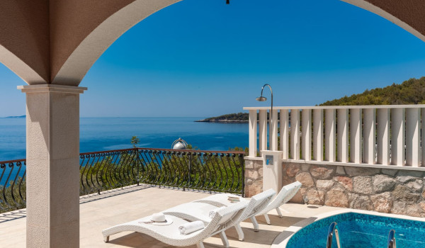 Deck chairs by the pool on the terrace of the luxury vacation villa with concierge service and private parking