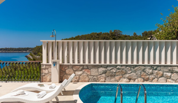 Deck chairs by the pool on the terrace of the luxury vacation villa with concierge service and private parking