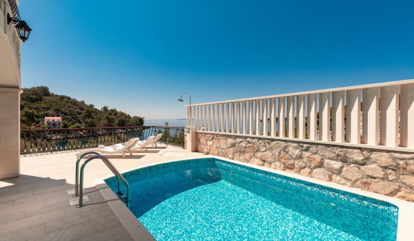 Private heated pool and deck chairs on the terrace of the luxury beachfront villa for family vacation on Korcula island