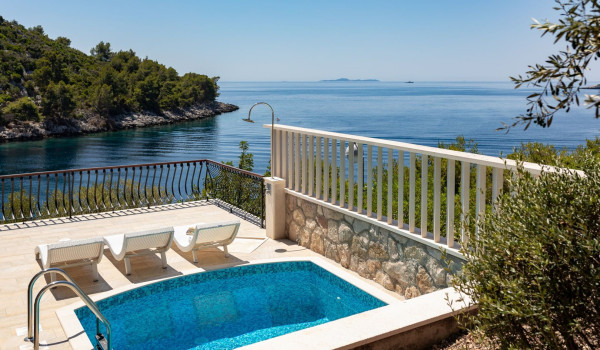 Deck chairs by the pool on the terrace of the luxury vacation villa with concierge service and private parking