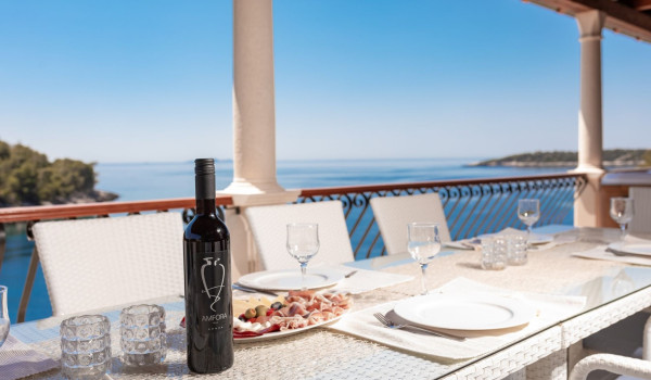 Traditional dinner on the outdoor dining table with sea view of the luxury holiday villa with private pool and jacuzzi