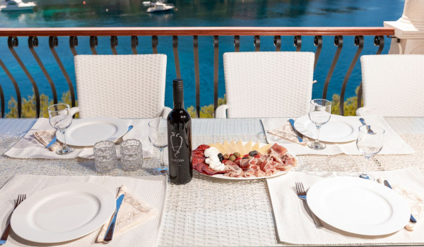 Traditional dinner on the outdoor dining table with sea view of the luxury holiday villa with private pool and jacuzzi