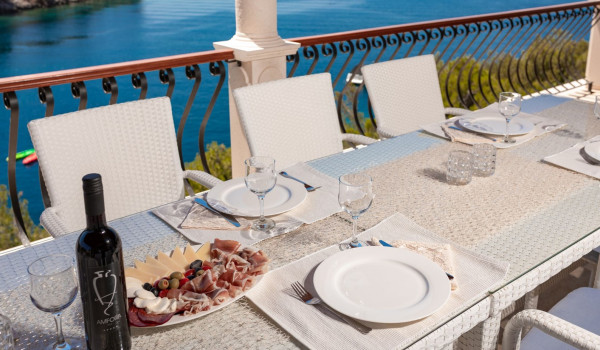 Traditional dinner on the outdoor dining table with sea view of the luxury holiday villa with private pool and jacuzzi
