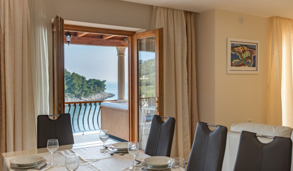 Dining table in the living room with direct entrance to the terrace of the luxury villa Korcula Magnificent with concierge service and private mooring