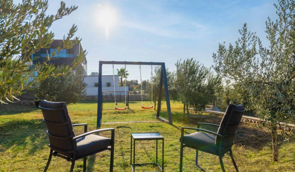 Spacious garden with children playground, swing and seating area in luxury istrian villa with heated pool