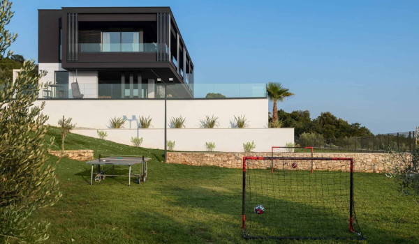 Spacious garden with children playground, swing and seating area in luxury istrian villa with heated pool