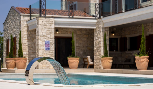 A view of the waterfall of the outdoor heated pool measuring 75 m2 on the property of a private luxury villa