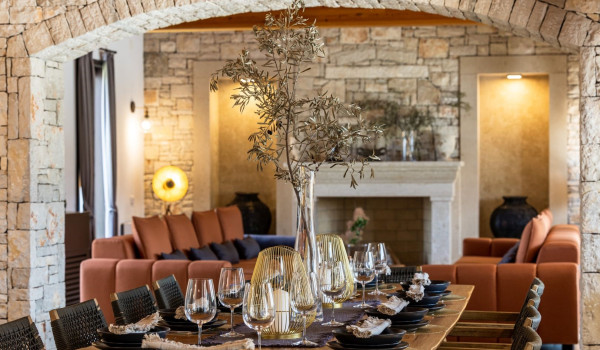 A dining area with a table and 10 chairs next to a spacious living room and a fully equipped kitchen on the ground floor of a private villa