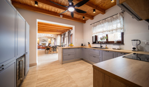 Fully equipped kitchen with a bar and two bar stools inside the ground floor of the Croatian luxury villa for vacation and rent