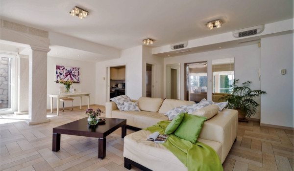 Living room with large comfortable sofa and working space of a luxury holiday villa with private pool and concierge service