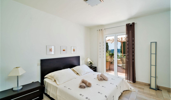 Queen size bed in a bedroom of the Luxury family villa with private pool and jacuzzi in Dubrovnik