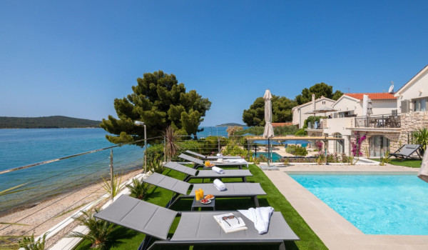 A spacious, modernly decorated courtyard of a luxurious Croatian private villa with a swimming pool