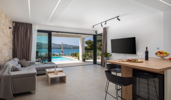 Modernly decorated living room with a fully equipped kitchen and a view of the sea