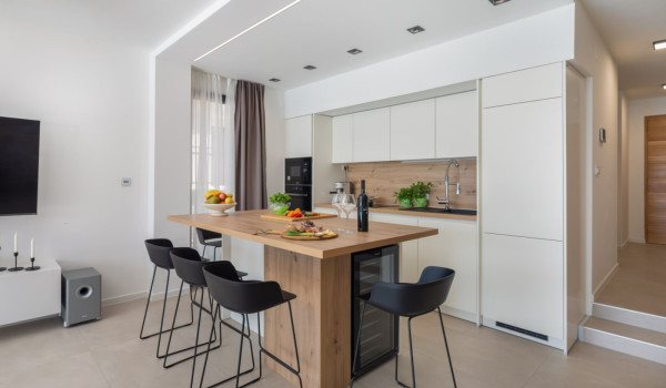 Modernly decorated living room with a fully equipped kitchen and a view of the sea