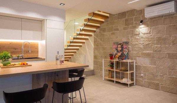 Modernly decorated living room with a fully equipped kitchen and a view of the sea