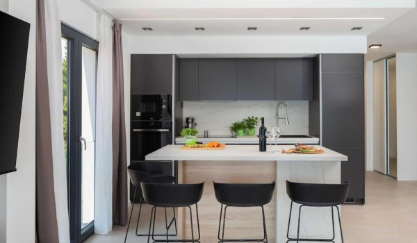 Fully equipped kitchen with bar and bar stools inside a luxury Croatian villa for rent and vacation