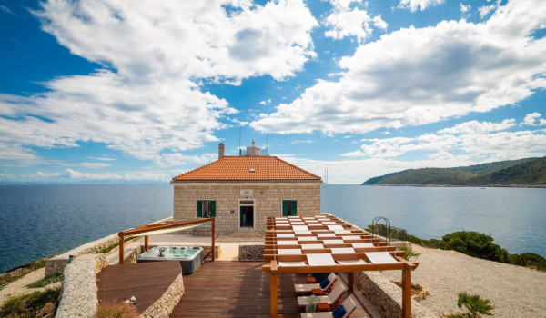 Terrace with jacuzzi and sunbathing area in luxury seafront villa on Vis for vacation and rent.