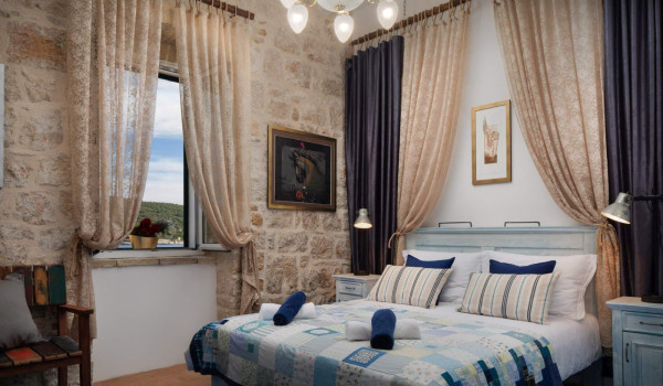 Rustic bedroom with King-size bed and en suite bathroom in luxury villa on Vis by the sea with jacuzzi.
