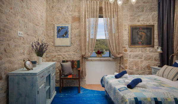 Rustic bedroom with King-size bed and en suite bathroom in Croatian luxury holiday villa on Vis by the sea with jacuzzi.