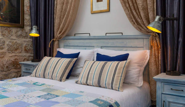 Rustic bedroom with King-size bed and en suite bathroom in luxury seafornt villa Lighthouse Ligero on Vis for vacation and rent.