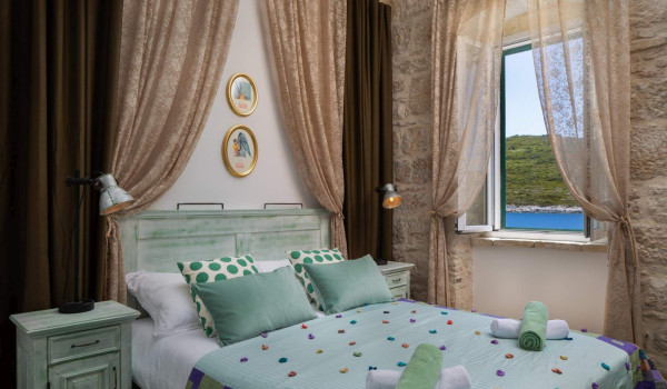 Spacious bedroom with King-size bed and en suite bathroom in luxury villa on Vis for vacation and rent.