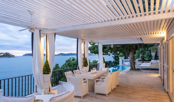 Terrace of the Croatia luxury beachfront villa with dining table and seating area by the pool