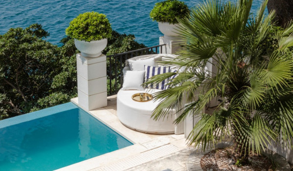 Lounge chairs by the pool on the private terrace of the beachfront vacation villa for familes