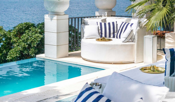 Lounge chairs by the pool on the private terrace of the beachfront vacation villa for family vacation