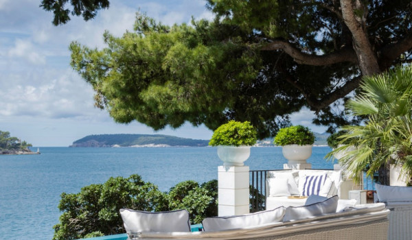 Lounge chairs by the pool on the private terrace of the beachfront vacation villa for family vacation