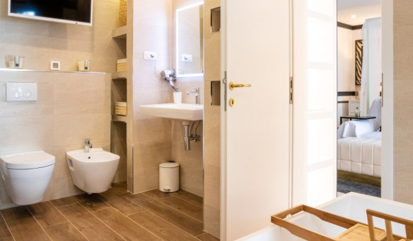En suite bathroom with tub, sink, toilet, bidet and TV in the luxury beachfront villa in Dubrovnik