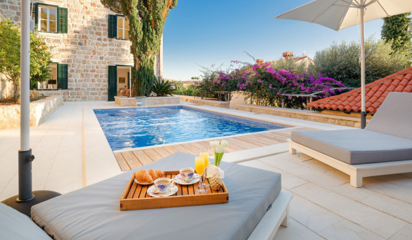 Private terrace of Croatia luxury rental villa with pool surrounded by deckchairs and sundeck