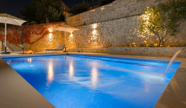 Private terrace of Croatia luxury villa with pool surrounded by deckchairs and sundeck for vacation
