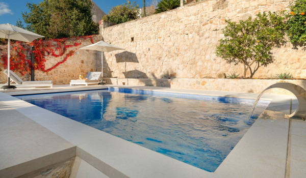 Private terrace of Croatia luxury villa with pool surrounded by deckchairs and sundeck for vacation