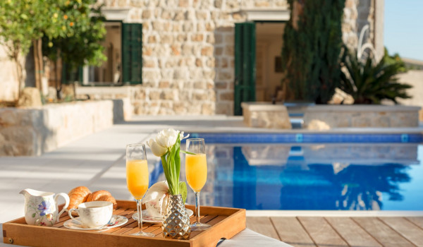 Private terrace of Croatia luxury villa with pool surrounded by deckchairs and sundeck for vacation