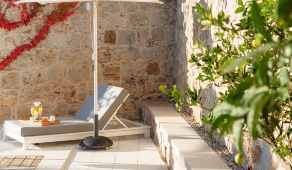 Private terrace of Croatia luxury villa with pool surrounded by deckchairs and sundeck for vacation