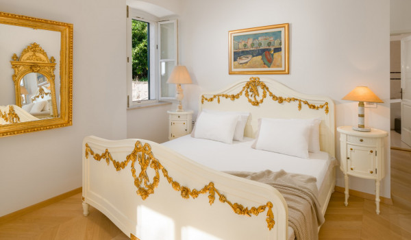 Bedroom of Croatia luxury pool villa with king-size bed and night stands with lamps for vacation