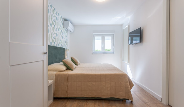 Double bed in a bedroom of a family villa Sea Hug