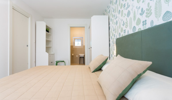 Double bed in a bedroom of a family villa Sea Hug