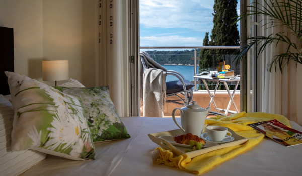 Queen size bed in a bedroom with private terrace overlooking the sea in the luxury holiday villa for families and friends in Dubrovnik