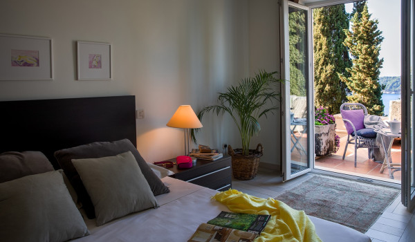 King size bed in the bedroom with direct entrance to the terrace of the luxury seafront villa with concierge service in Dubrovnik