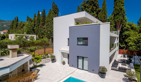 Private courtyard and outdoor kitchen with dining table and chairs for 12 persons on the roofed patio near the private pool