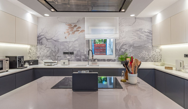 Large kitchen island with hood and stove in the modern kitchen on the ground floor of the luxury villa Velvet Bourbon Split