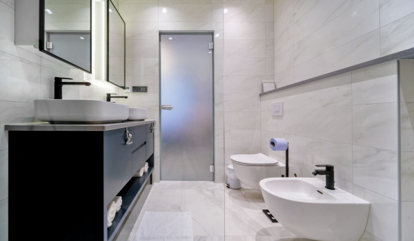 The interior of a contemporary en suite bathroom with white marble tiles inside Croatian luxury holiday villa