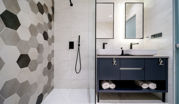 Walk in shower and washbasins in the modern en suite bathroom filled with light