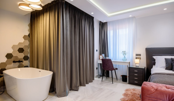 Bathtub next to the en suite bathroom with shower in the spacious bedroom