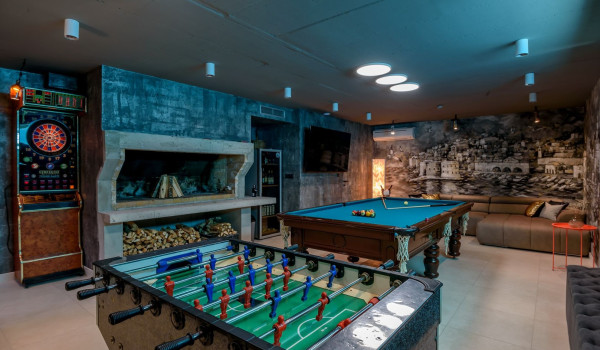 Basement converted into the relaxation room with billiards, table football, refrigerator, fireplace and darts