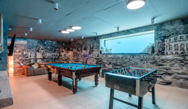 Entertainment area with table football, pool table and comfortable couch in the basement of the luxury villa Velvet Bourbon Split